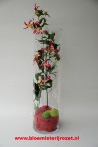 Gloriosa bloem en vaas verwerkt van doorsnede 25 cm. hoogte 70 cm.